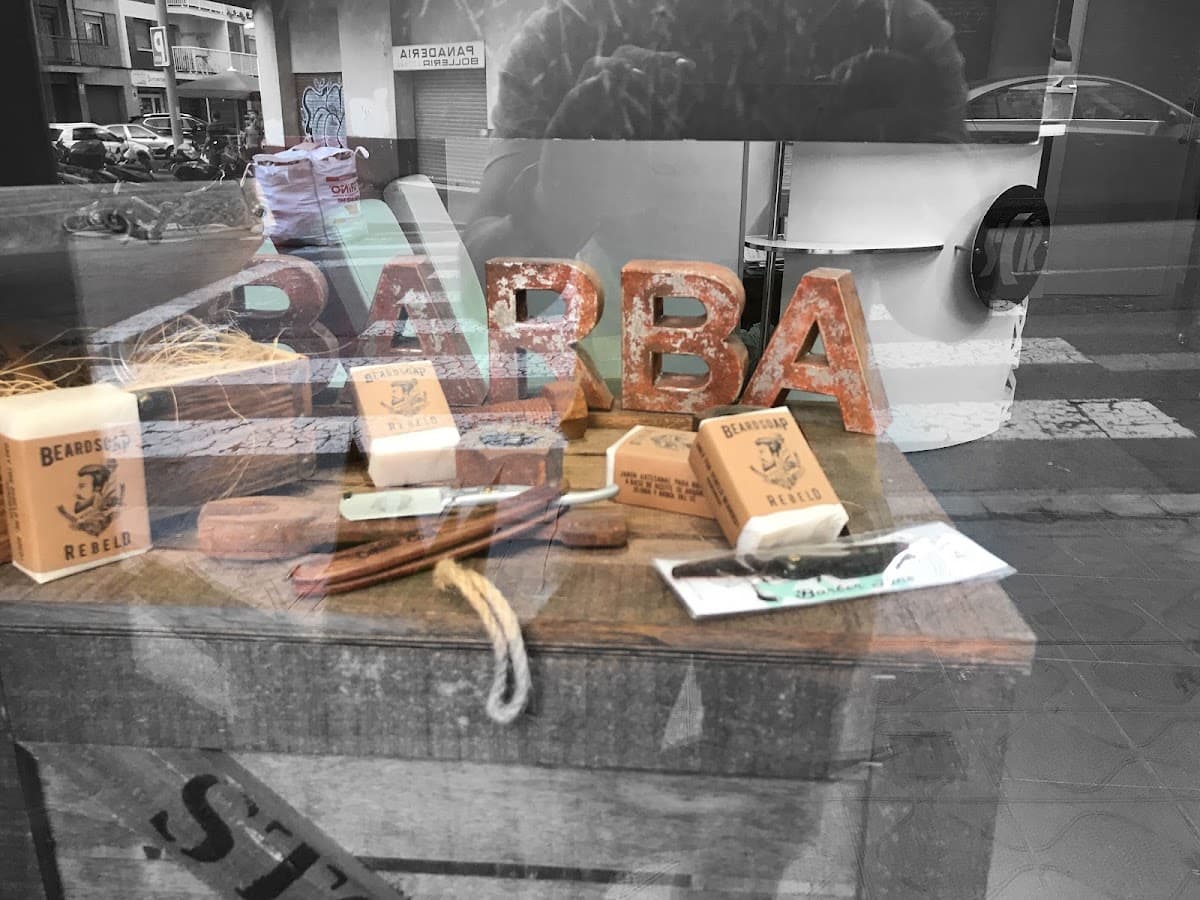 Escaparate de SCR Barber con navaja de afeitar, jabones de barba artesanales y letras decorativas BARBA